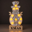 Rozsvícený dřevěný sněhulák XMAS za šera